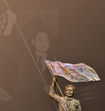 A photo and relief of Chairman Lee Kun-hee waving a Samsung flag at his inauguration as Chairman in December 1987.