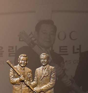 A photo and relief of Chairman Lee Kun-hee and IOC President Samaranch holding a torch after signing the Olympic Partnership in 1997.