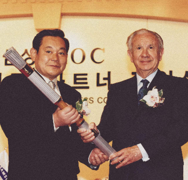 A photo of Chairman Lee Kun-hee and IOC President Samaranch holding a torch during the 1997 Samsung-IOC Olympic Partnership Signing Ceremony.