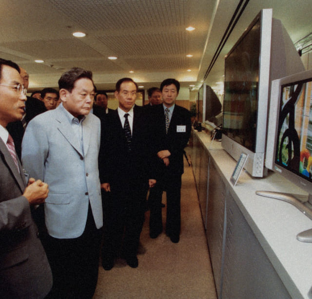 A photo of Chairman Lee Kun-hee inspecting products at the Digital New Products Exhibition in 2002.