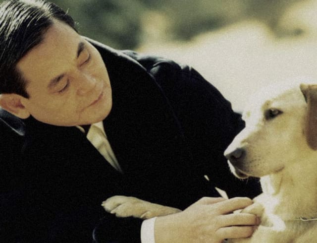 A photo of Chairman Lee Kun-hee petting a guide dog for the visually impaired.