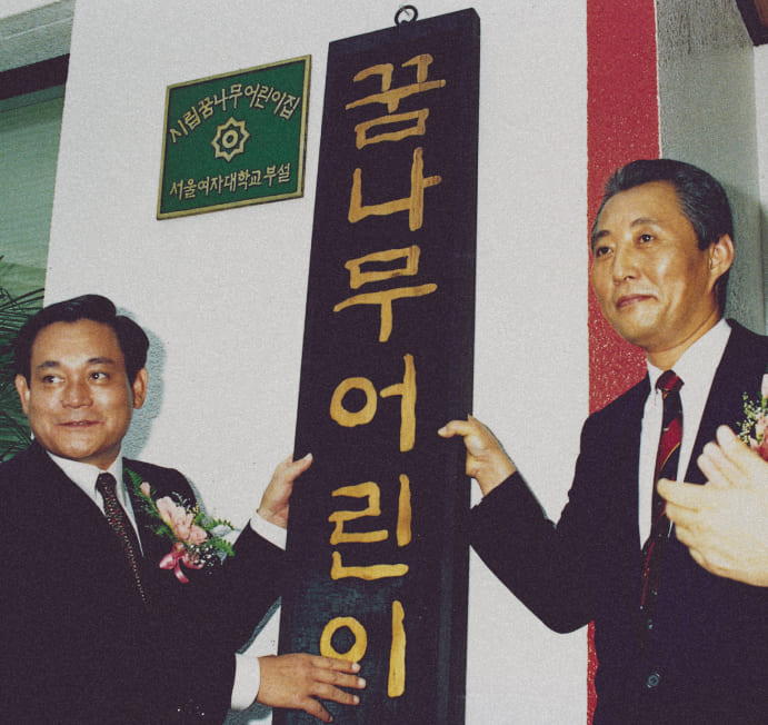 A photo of Chairman Lee Kun-hee putting up the sign for the Samsung Daycare Center in July 1990.