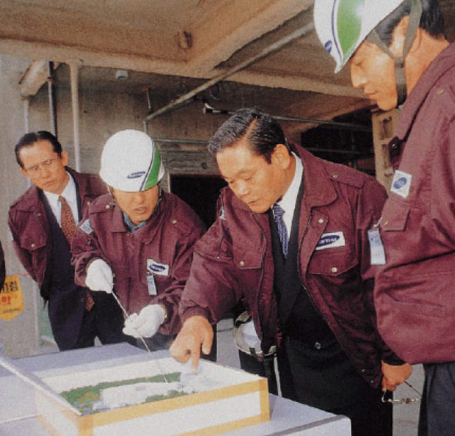 A photo of Chairman Lee Kun-hee inspecting a building with staff during his visit to the Samsung Medical Center construction site in April 1993.